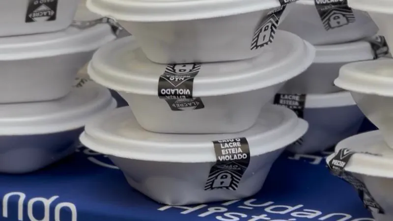 Marmitas lacradas empilhadas sobre a mesa com a toalha azul da Mudando Histórias